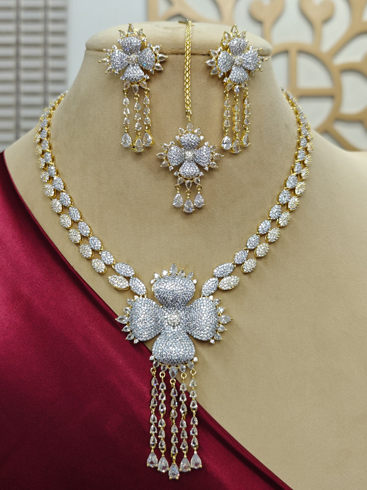 "A bride-to-be wearing an exquisite artificial diamond necklace and matching earrings and matching maangtikka, designed for the perfect engagement look. This stunning artificial diamond jewelry set offers luxury and sophistication while being an affordable alternative to natural diamonds."