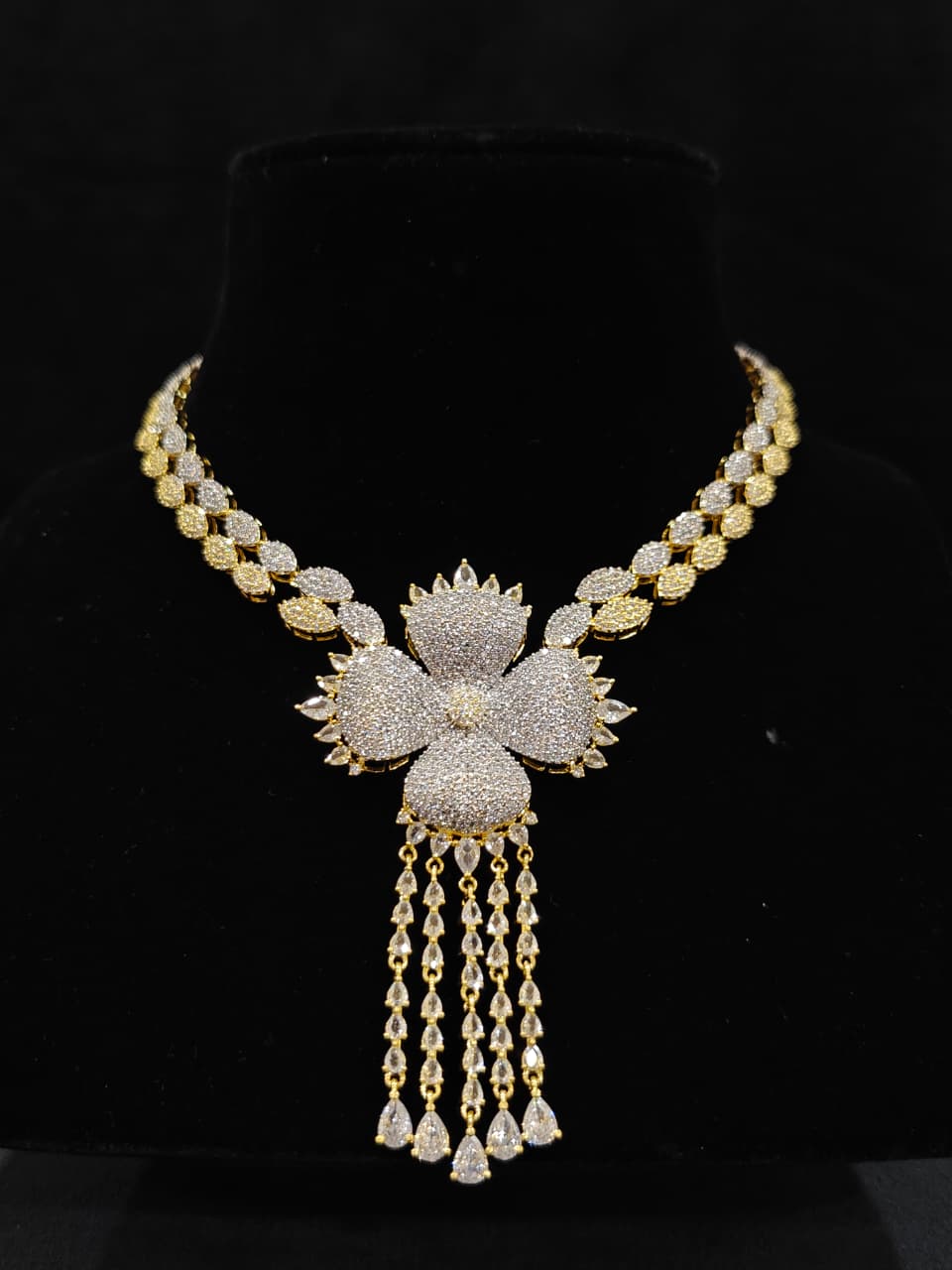 A glamorous artificial diamond necklace paired with chic earrings and maangtikka, perfect for bridal wear. This high-quality artificial diamond jewelry set. Close-up of a cocktail party look featuring a premium American diamond necklace.