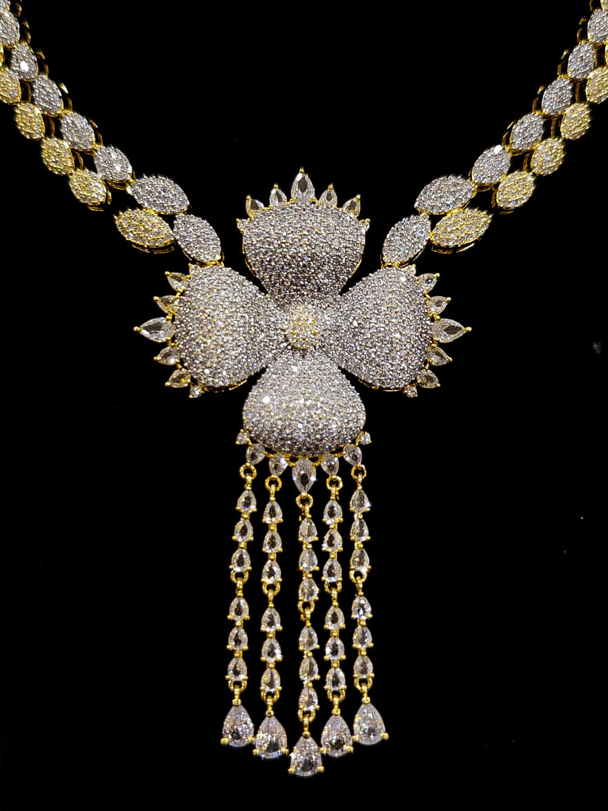 A glamorous artificial diamond necklace paired with chic earrings and maangtikka, perfect for bridal wear. This high-quality artificial diamond jewelry set. Close-up of a cocktail party look featuring a premium American diamond necklace.