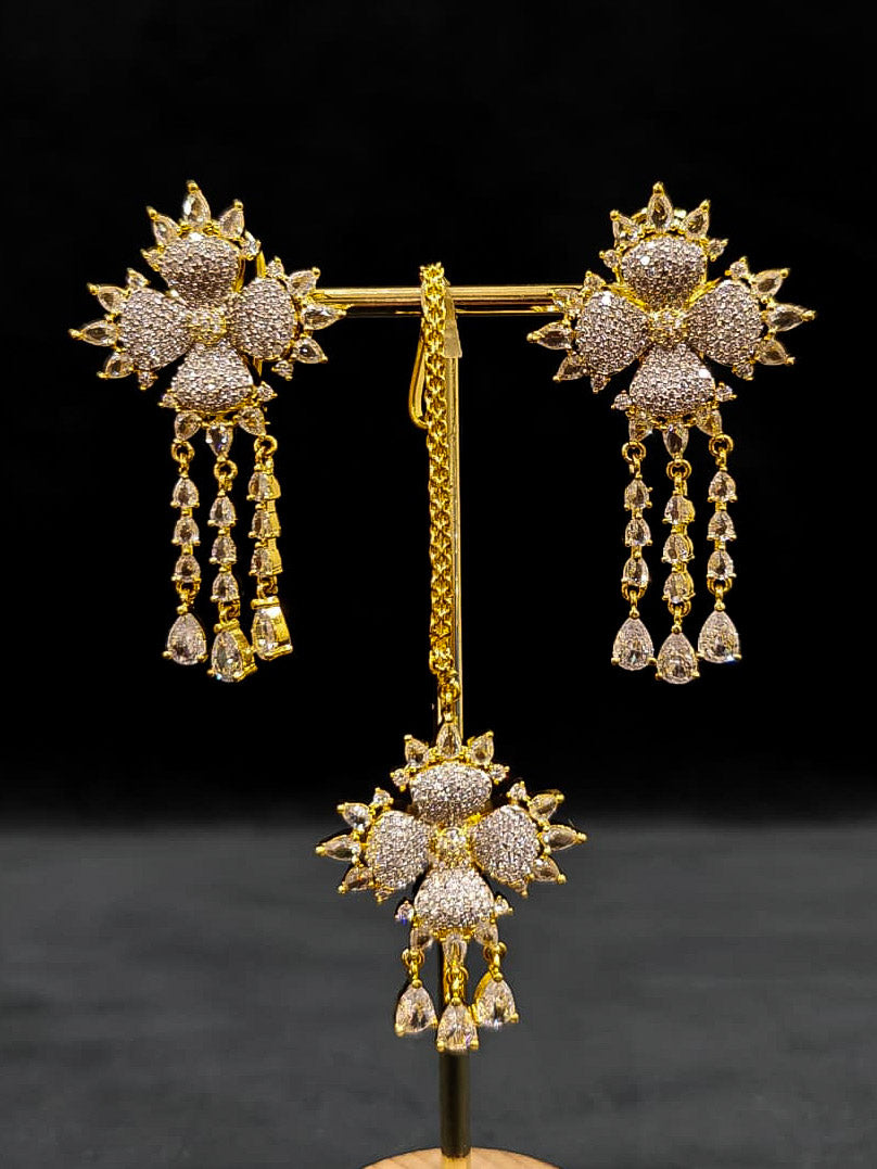 A glamorous artificial diamond necklace paired with chic earrings and maangtikka, perfect for bridal wear. This high-quality artificial diamond jewelry set. Close-up of a cocktail party look featuring a premium American diamond necklace.