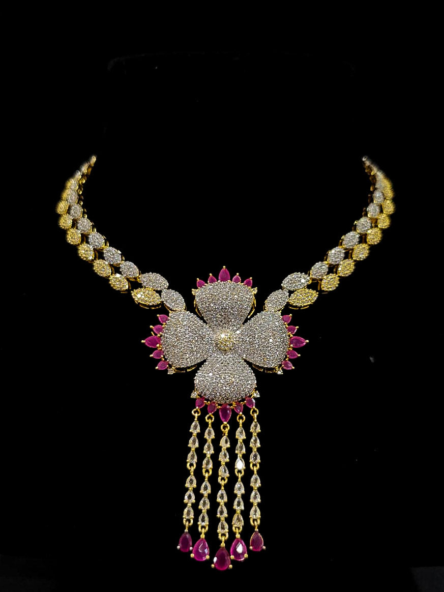 An exquisite artificial diamond necklace with pink colored stone and matching earrings and maangtikka, designed for the perfect engagement look. This stunning artificial diamond jewelry set offers luxury and sophistication while being an affordable alternative to natural diamonds.
