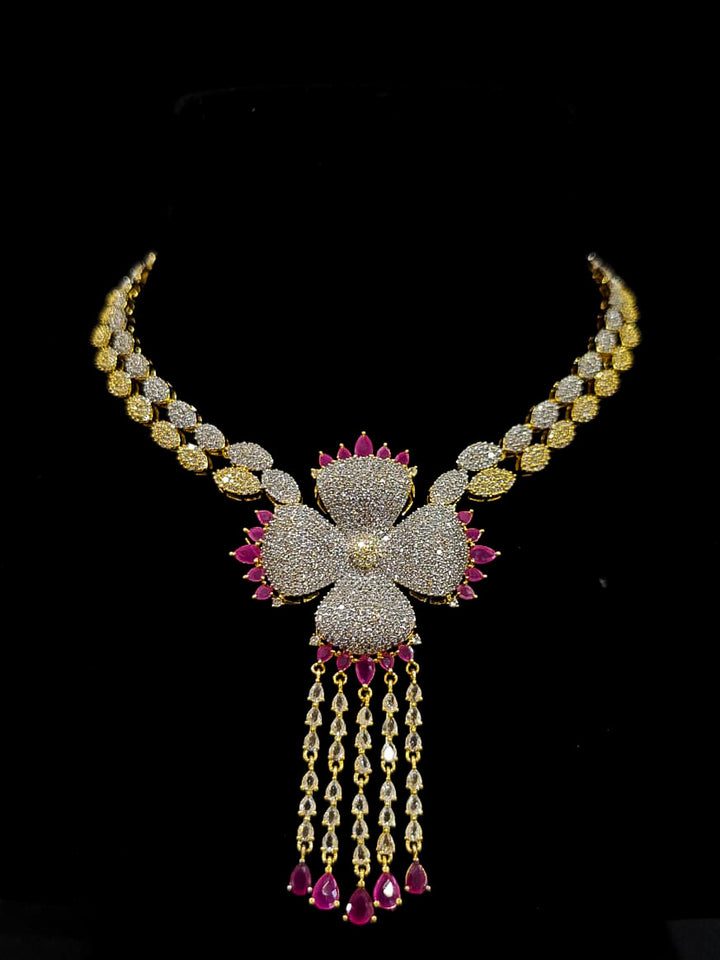 An exquisite artificial diamond necklace with pink colored stone and matching earrings and maangtikka, designed for the perfect engagement look. This stunning artificial diamond jewelry set offers luxury and sophistication while being an affordable alternative to natural diamonds.