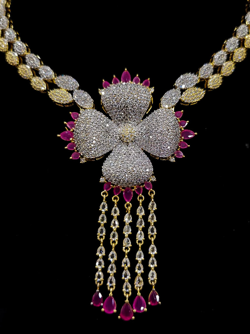 An exquisite artificial diamond necklace with pink colored stone and matching earrings and maangtikka, designed for the perfect engagement look. This stunning artificial diamond jewelry set offers luxury and sophistication while being an affordable alternative to natural diamonds.