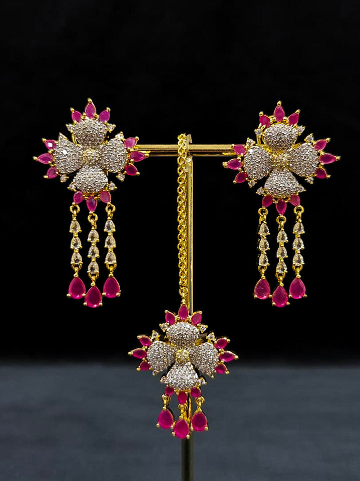 An exquisite artificial diamond necklace with pink colored stone and matching earrings and maangtikka, designed for the perfect engagement look. This stunning artificial diamond jewelry set offers luxury and sophistication while being an affordable alternative to natural diamonds.
