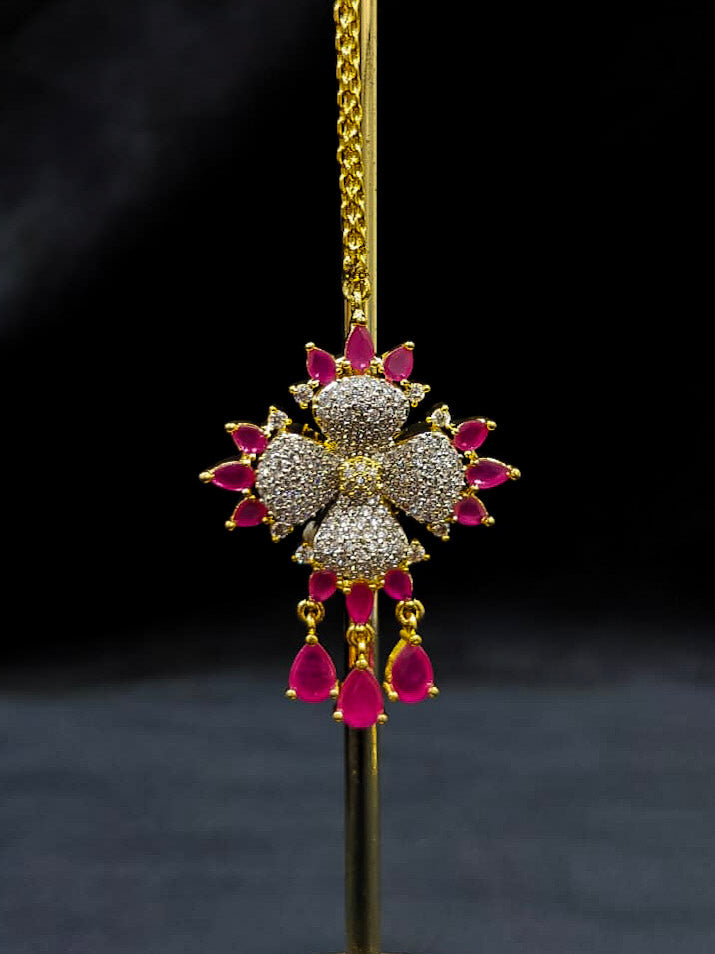 An exquisite artificial diamond necklace with pink colored stone and matching earrings and maangtikka, designed for the perfect engagement look. This stunning artificial diamond jewelry set offers luxury and sophistication while being an affordable alternative to natural diamonds.