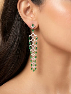 Close-up of a woman wearing an ornate Western (Silver Polish) Green Long Diamond Earrings with American Diamond and Colored. Model wearing a lightweight American diamond Earrings perfect for long wedding functions. Close-up of a cocktail party look featuring a premium American diamond Earrings.