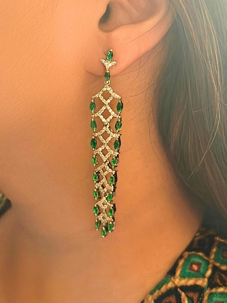 Close-up of a woman wearing an ornate Western (Silver Polish) Green Long Diamond Earrings with American Diamond and Colored. Model wearing a lightweight American diamond Earrings perfect for long wedding functions. Close-up of a cocktail party look featuring a premium American diamond Earrings.