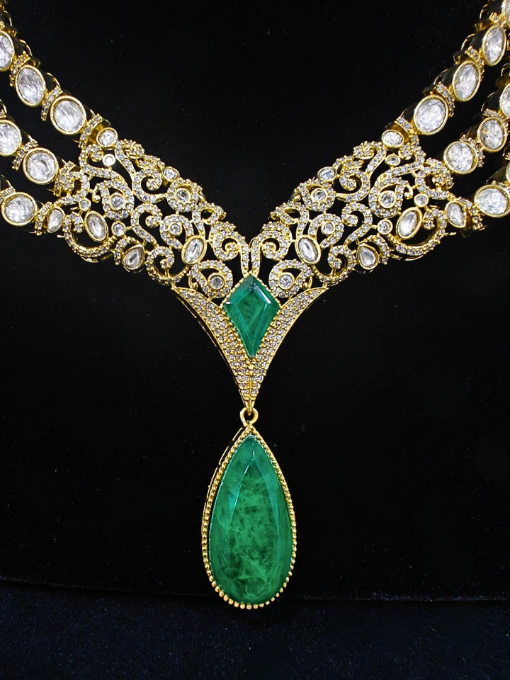 A glamorous artificial diamond and green colored stone and kudan polki necklace paired with chic earrings, perfect for bridal wear. This high-quality artificial diamond jewelry set is the ideal choice for modern brides looking for a budget-friendly option with timeless sparkle."