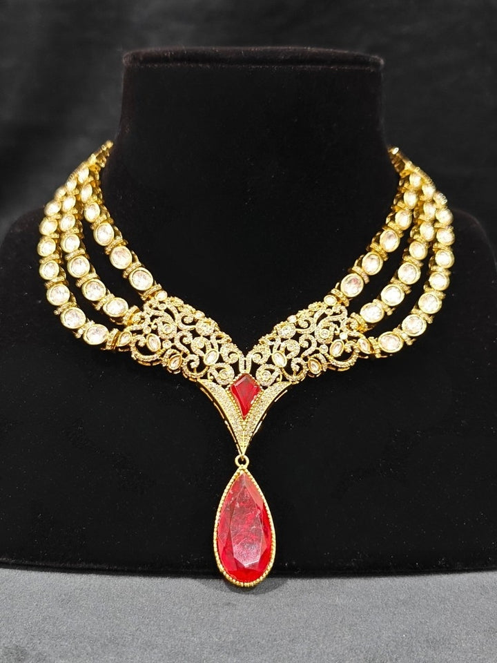 An exquisite artificial diamond and red colored stone and kundan polki necklace and matching earrings, designed for the perfect engagement look. This stunning artificial diamond jewelry set offers luxury and sophistication while being an affordable alternative to natural diamonds."