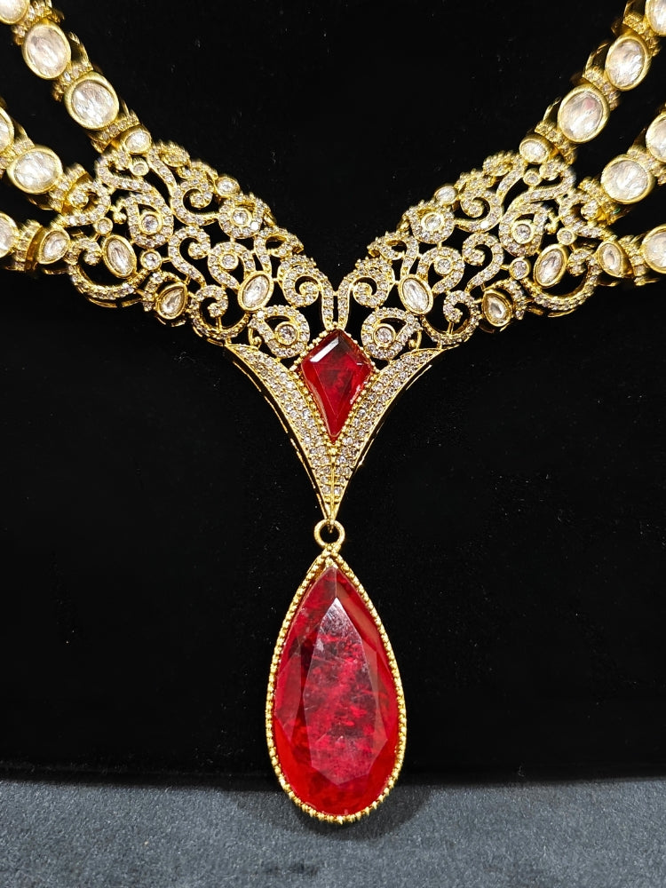 An exquisite artificial diamond and red colored stone and kundan polki necklace and matching earrings, designed for the perfect engagement look. This stunning artificial diamond jewelry set offers luxury and sophistication while being an affordable alternative to natural diamonds."