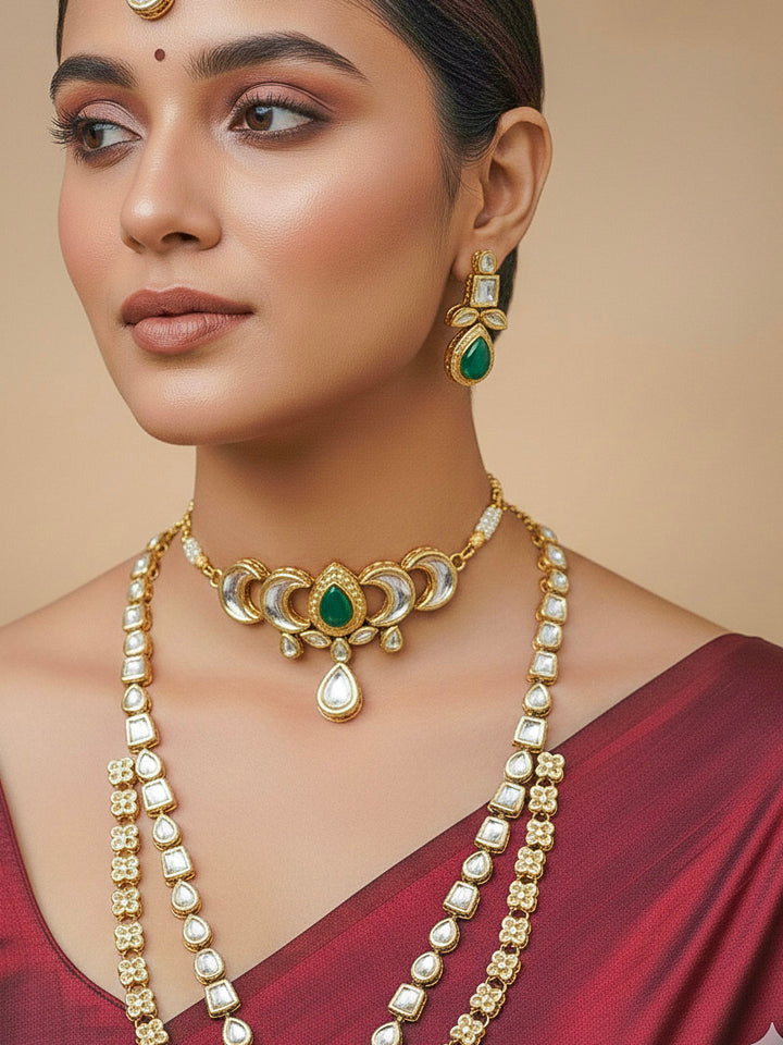 Close-up of a woman wearing an ornate traditional (Gold Polish) Dark Green Long Kundan jewellery set and earrings and a Choker and Mangtikka with Kundan and Colored Stones. Wedding celebration look enhanced with a statement Kundan necklace. Bride wearing a royal Kundan artificial necklace for wedding rituals.