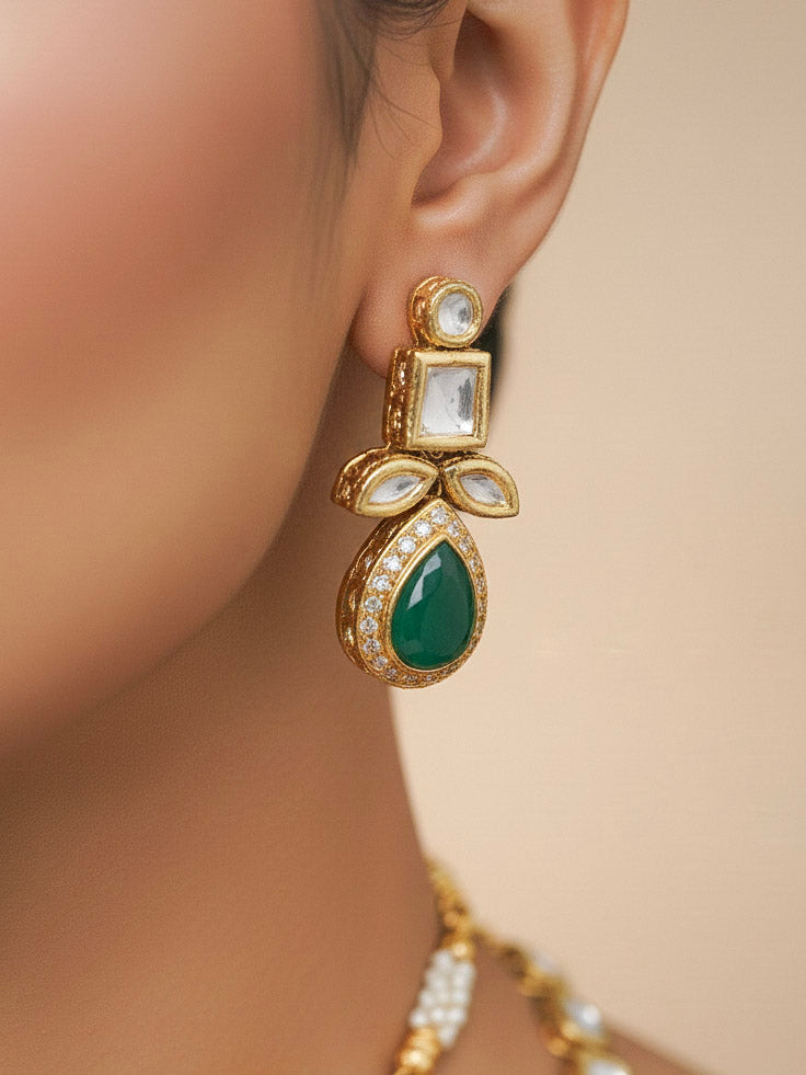 Close-up of a woman wearing an ornate traditional (Gold Polish) Dark Green Long Kundan jewellery set and earrings and a Choker and Mangtikka with Kundan and Colored Stones. Wedding celebration look enhanced with a statement Kundan necklace. Bride wearing a royal Kundan artificial necklace for wedding rituals.