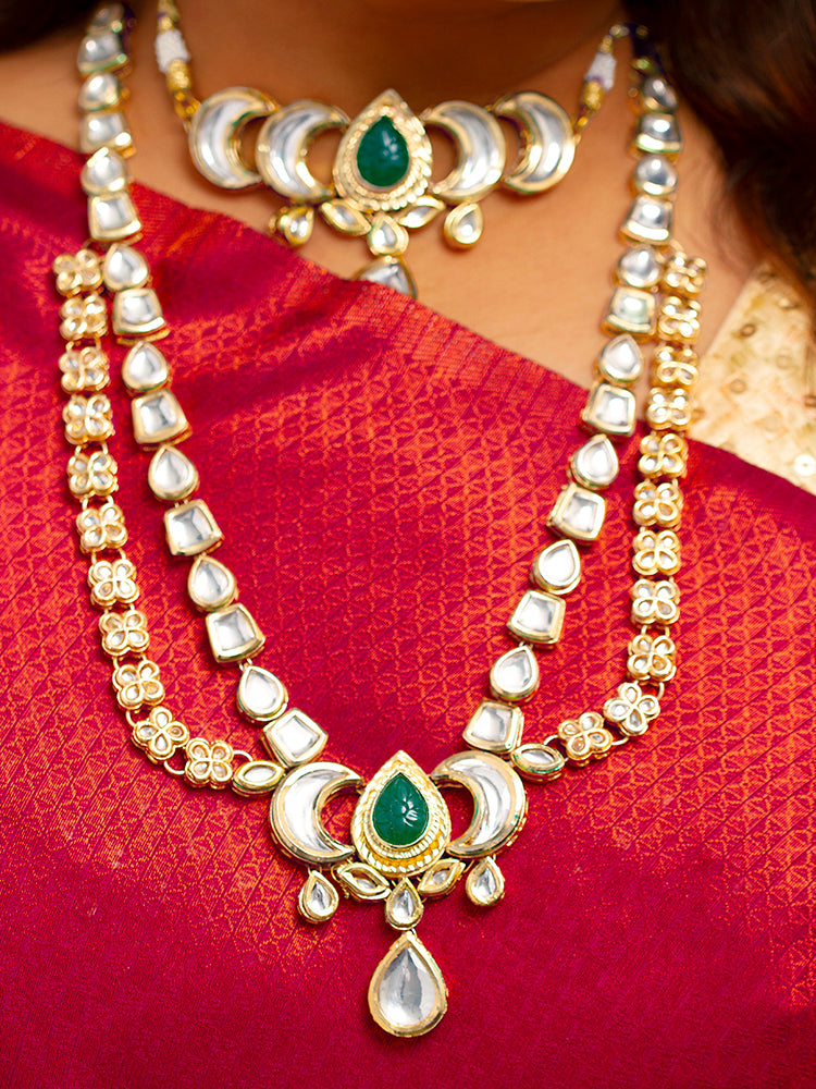 Close-up of a woman wearing an ornate traditional (Gold Polish) Dark Green Long Kundan jewellery set and earrings and a Choker and Mangtikka with Kundan and Colored Stones. Wedding celebration look enhanced with a statement Kundan necklace. Bride wearing a royal Kundan artificial necklace for wedding rituals.