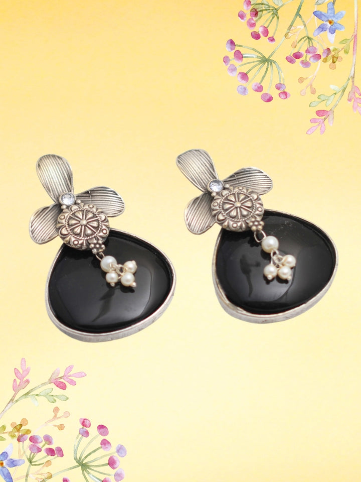 David Black oxidized Earrings feature silver flower-shaped tops, decorative floral details, and Black teardrop stones. Small white pearls dangle at the center, adding a touch of elegance to these stylish german silver earrings.  Oxidized earrings from the oxidized jewelry collection. 