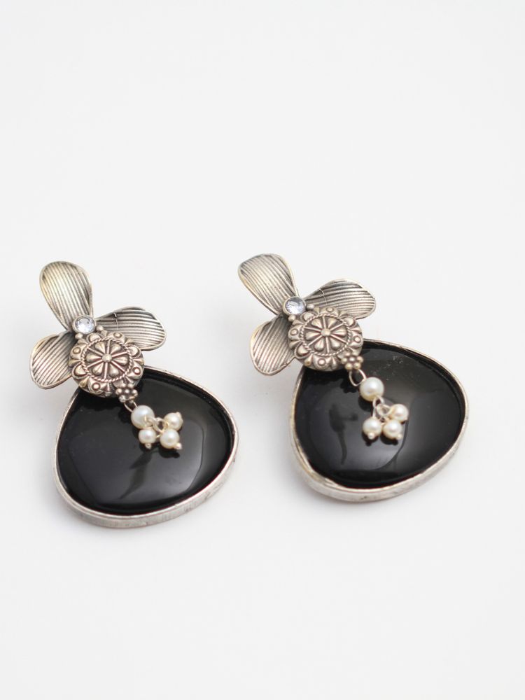 David Black oxidized Earrings feature silver flower-shaped tops, decorative floral details, and Black teardrop stones. Small white pearls dangle at the center, adding a touch of elegance to these stylish german silver earrings.  Oxidized earrings from the oxidized jewelry collection. 