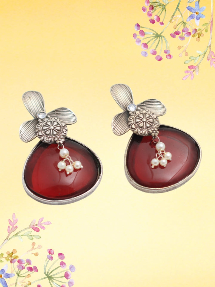 David Maroon oxidized Earrings feature silver flower-shaped tops, decorative floral details, and Maroon teardrop stones. Small white pearls dangle at the center, adding a touch of elegance to these stylish german silver earrings.  Oxidized earrings from the oxidized jewelry collection. 
