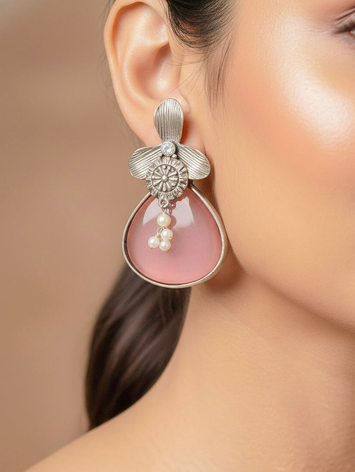 Close-up of a woman wearing an ornate Western (Silver Polish) Mint Pink Oxidised Earrings with Mint Pink Colored Stone and Pearl. Festive Diwali look styled with premium artificial  Oxidised earrings. 