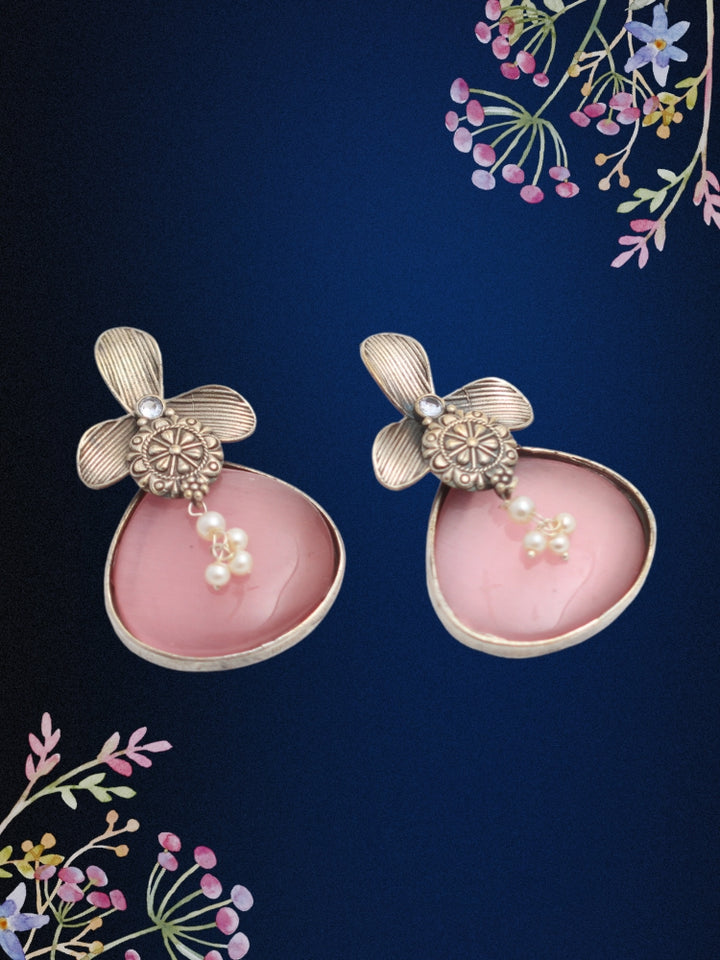 David Pink oxidized Earrings feature silver flower-shaped tops, decorative floral details, and Pink teardrop stones. Small white pearls dangle at the center, adding a touch of elegance to these stylish german silver earrings.  Oxidized earrings from the oxidized jewelry collection. 