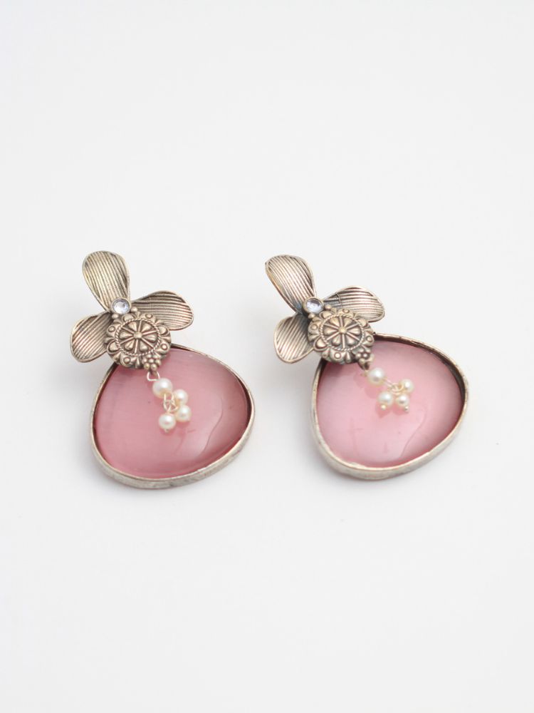 David Pink oxidized Earrings feature silver flower-shaped tops, decorative floral details, and Pink teardrop stones. Small white pearls dangle at the center, adding a touch of elegance to these stylish german silver earrings.  Oxidized earrings from the oxidized jewelry collection. 