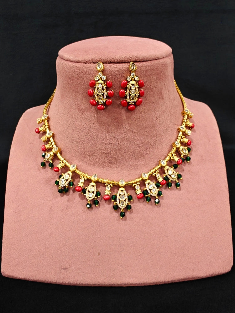 Close-up of an ornate traditional (Gold Polish) Collar jewellery set and earrings with Colored Stone, Beads and American Diamonds. Festive Diwali outfit paired with a colorful Colored Stone necklace. Mehendi ceremony look completed with a Colored Stone  jewelry set.