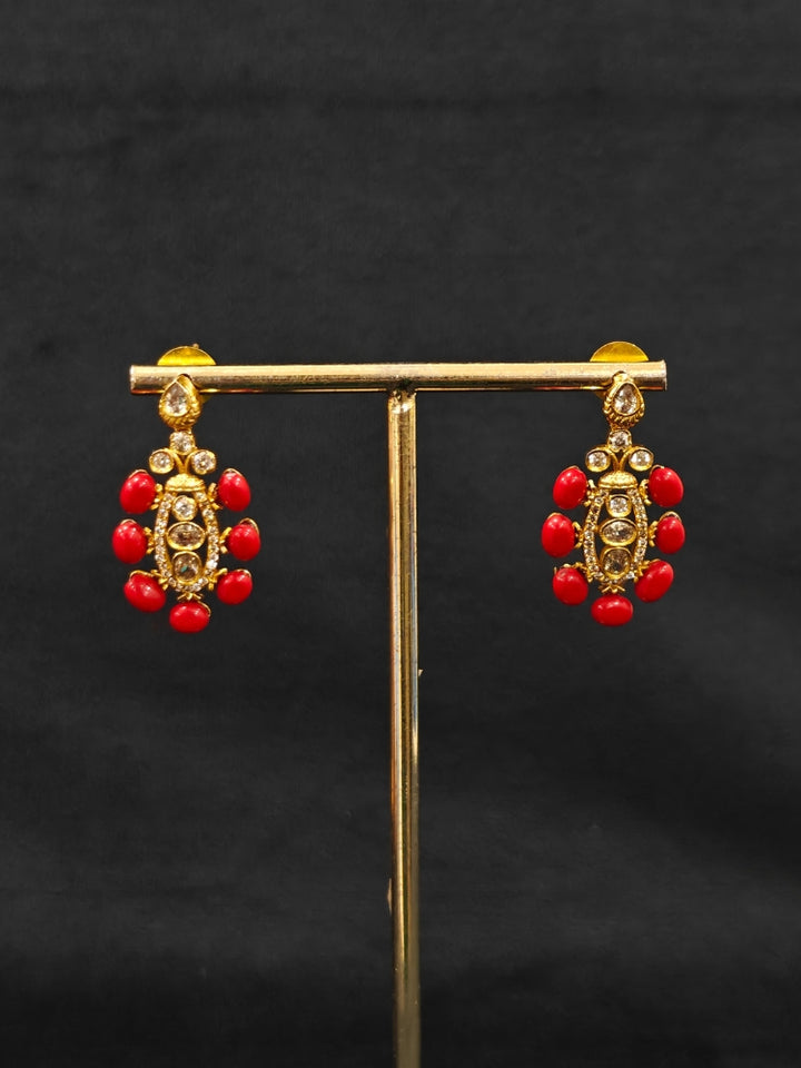 Close-up of an ornate traditional (Gold Polish) Collar jewellery set and earrings with Colored Stone, Beads and American Diamonds. Festive Diwali outfit paired with a colorful Colored Stone necklace. Mehendi ceremony look completed with a Colored Stone  jewelry set.