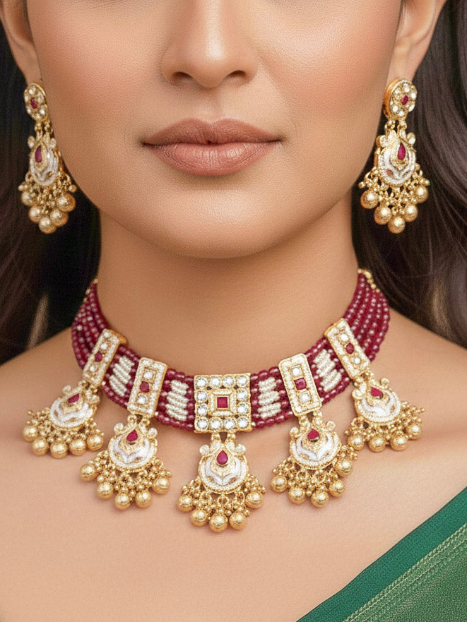 Close-up of a woman wearing an ornate traditional Ruby Pink Meenakari gold Choker jewellery set and earrings and maangtikka with Colored Stones, Pearls, Meenakari, Kundan and Crystal Beads. Festive Diwali outfit paired with a colorful Meenakari necklace. Close-up of detailed enamel craftsmanship in Meenakari jewelry.