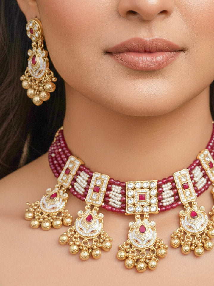 Close-up of a woman wearing an ornate traditional Ruby Pink Meenakari gold Choker jewellery set and earrings and maangtikka with Colored Stones, Pearls, Meenakari, Kundan and Crystal Beads. Festive Diwali outfit paired with a colorful Meenakari necklace. Close-up of detailed enamel craftsmanship in Meenakari jewelry.