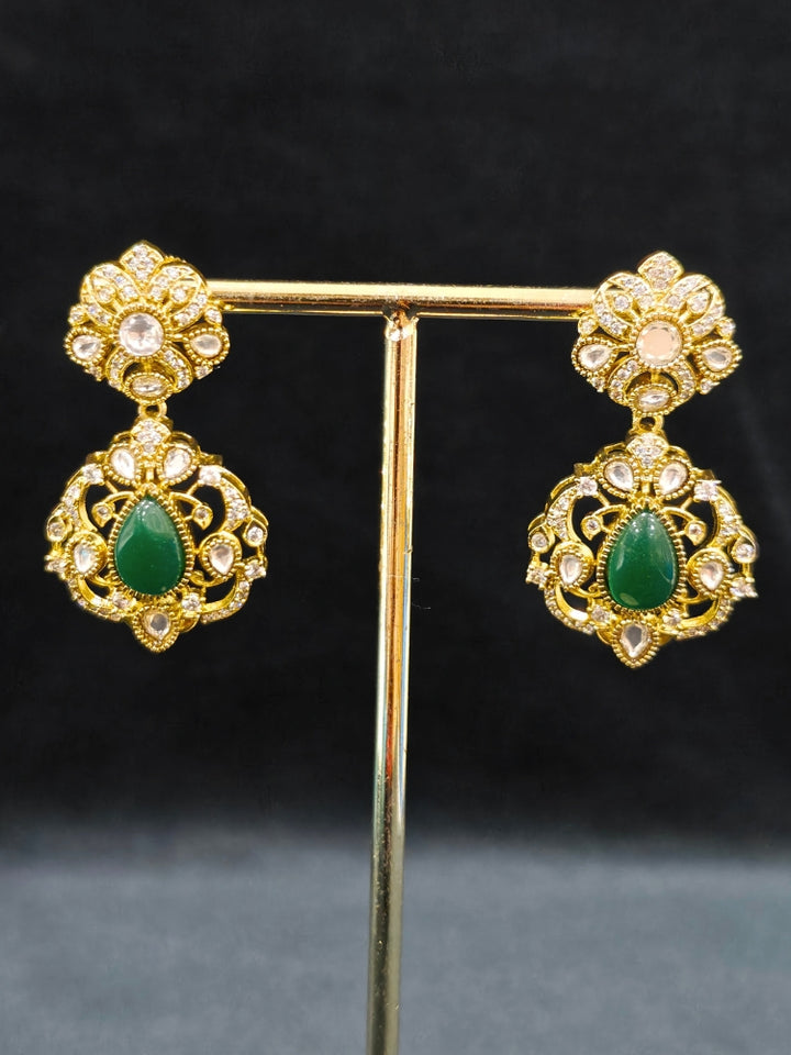 Close-up of an ornate traditional Green Heritage gold Long Layered jewellery set and earrings with colored Stone, Kundan and American Diamond. Mehendi ceremony styling featuring a premium heritage artificial jewelry piece. Styling a vintage heritage artificial necklace for a reception party.