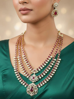 Close-up of a woman wearing an ornate traditional Red Heritage gold Long Layered jewellery set and earrings with colored Stone, Kundan and American Diamond. Mehendi ceremony styling featuring a premium heritage artificial jewelry piece. Traditional Indian look completed with a heritage artificial jewelry set.