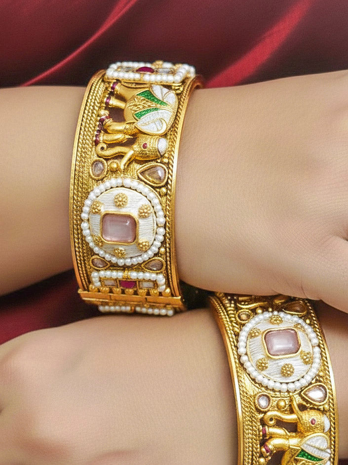 Close-up of a woman wearing an ornate traditional Rajwadi gold Bangle with Bandhai Work, Meenakari and Mint Pink Colored Stone. Woman wearing anti-tarnish artificial Rajwadi bangles for long functions. Traditional Indian jewelry look with artificial Rajwadi bangles. Close-up of enamel work in Meenakari artificial wedding Bangles.