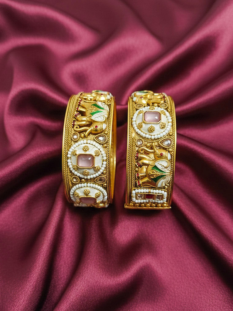 Close-up of an ornate traditional Rajwadi gold Bangle with Bandhai Work, Meenakari and Mint Pink Colored Stone. Anti-tarnish artificial Rajwadi bangles for long functions. Traditional Indian jewelry look with artificial Rajwadi bangles. Close-up of enamel work in Meenakari artificial wedding Bangles.