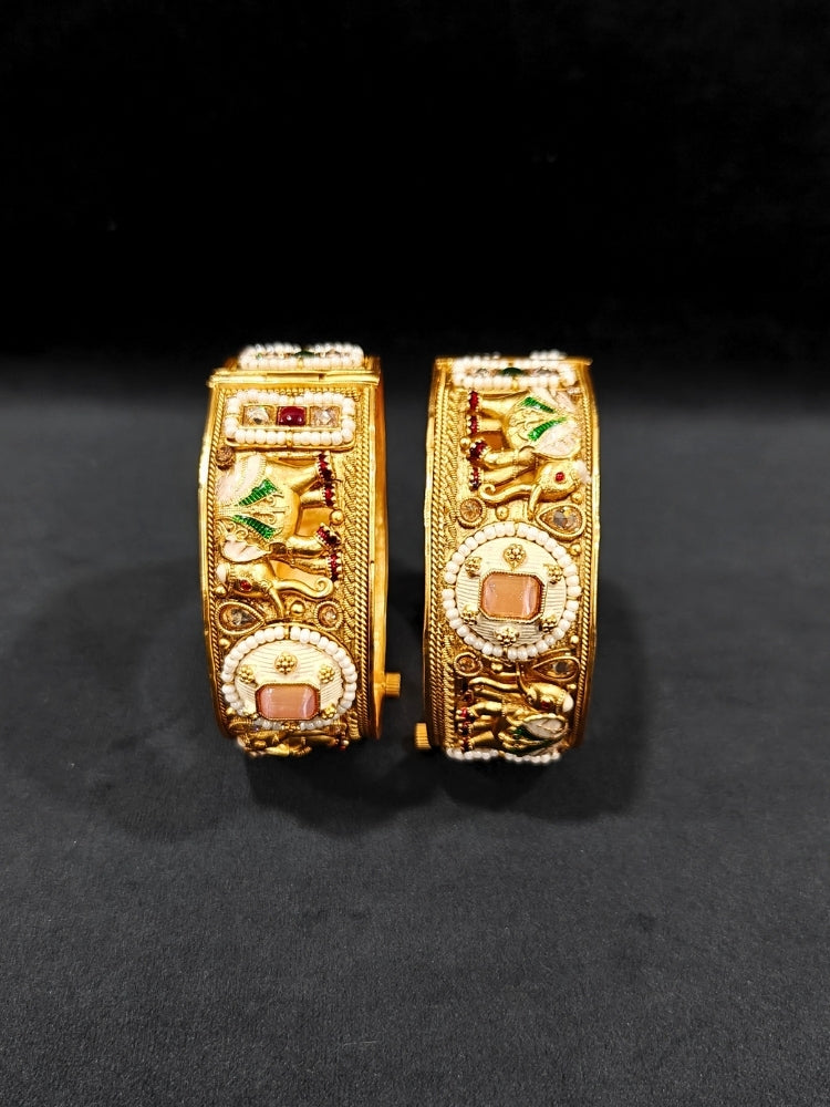Close-up of an ornate traditional Rajwadi gold Bangle with Bandhai Work, Meenakari and Mint Pink Colored Stone. Anti-tarnish artificial Rajwadi bangles for long functions. Traditional Indian jewelry look with artificial Rajwadi bangles. Close-up of enamel work in Meenakari artificial wedding Bangles.