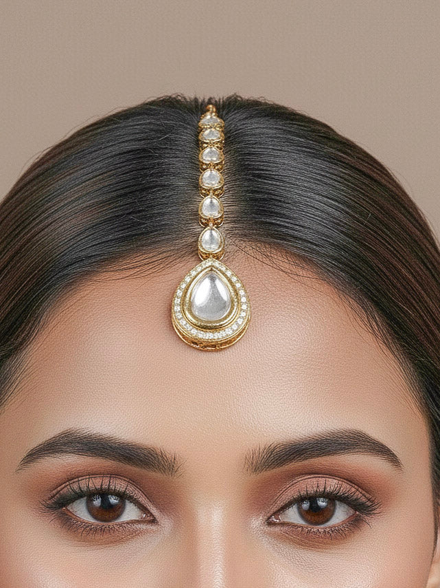 Close-up of a woman wearing an ornate traditional (Gold Polish) White Collar jewellery set and earrings and maangtikka with Kundan and American Diamonds. Woman wearing trending Kundan artificial jewelry for wedding season in India. Bride wearing a royal Kundan artificial necklace for wedding rituals.