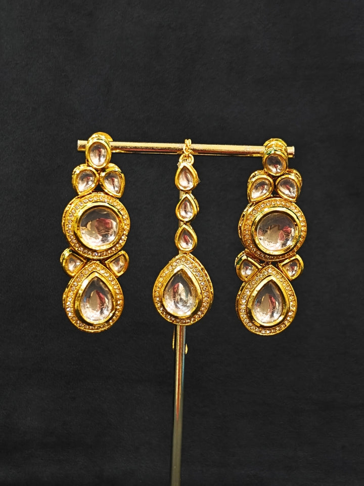 Close-up of an ornate traditional (Gold Polish) White Collar jewellery set and earrings and maangtikka with Kundan and American Diamonds. A trending Kundan artificial jewelry for wedding season in India. Bride wearing a royal Kundan artificial necklace for wedding rituals.