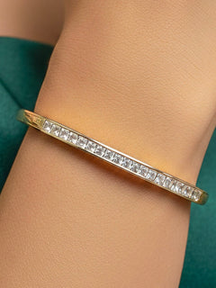 Close-up of a woman wearing an ornate Western (Gold & Silver Polish) Bracelet with American Diamond. Festive outfit paired with a premium imitation American Diamond bracelet in India. Close-up of skin-friendly artificial jewelry American Diamond bracelet in India.