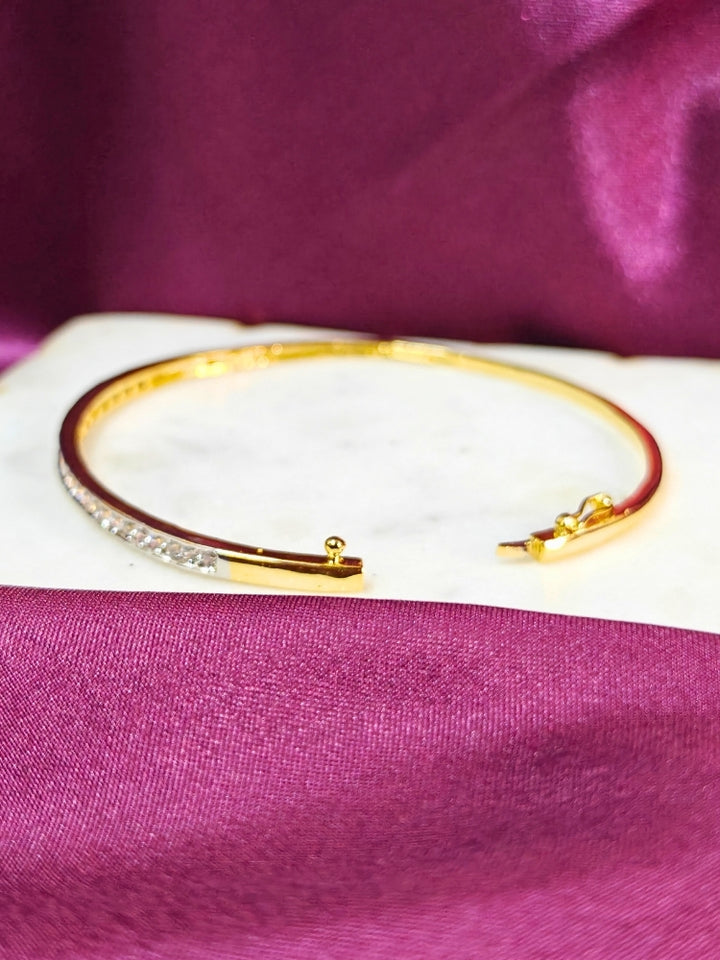 Close-up of a woman wearing an ornate Western (Gold & Silver Polish) Bracelet with American Diamond. Festive outfit paired with a premium imitation American Diamond bracelet in India. Close-up of skin-friendly artificial jewelry American Diamond bracelet in India.