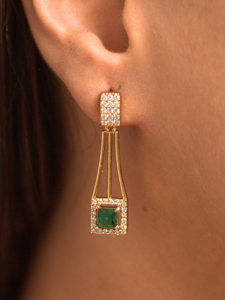 Close-up of a woman wearing an ornate Indo-western Green (gold Polish) Collar Layered Diamond jewellery set and earrings with American Diamond and Colored Stone. Party wear outfit completed with a lightweight American diamond necklace. Reception-ready look featuring a statement American diamond jewelry set.