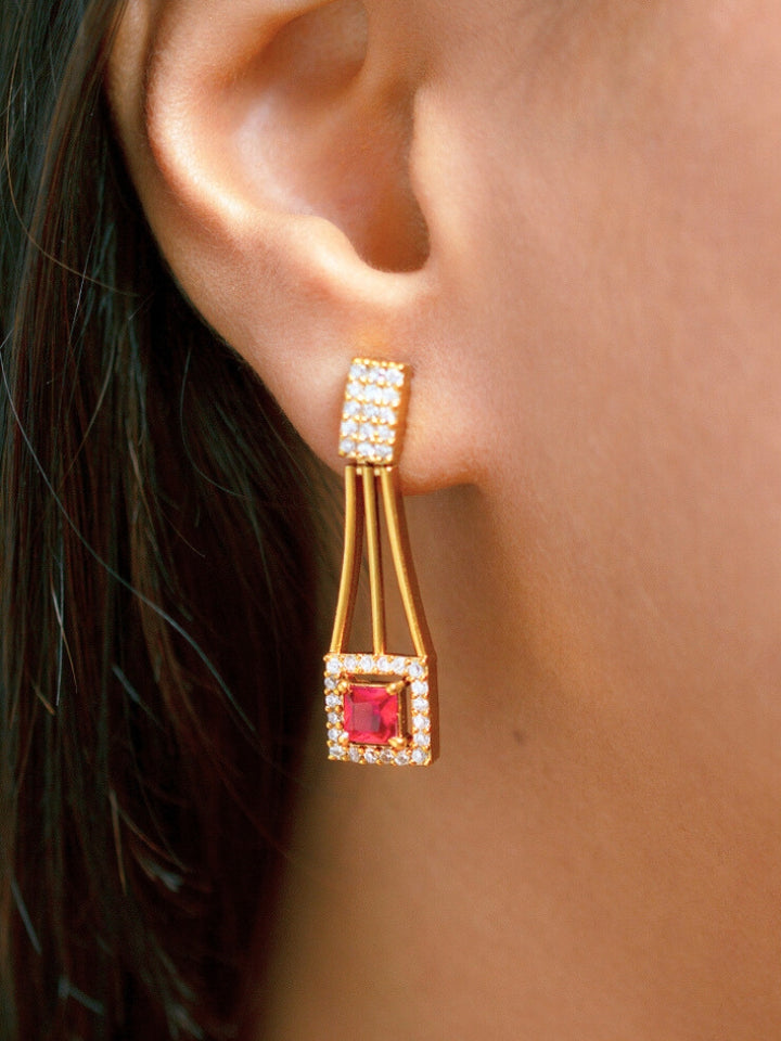 A woman wears the Diora Red Necklace Set, a gold party jewelry set featuring a red 2 layer necklace set made with  American diamonds and red gemstones at both the corners, paired with matching earrings. Only her lower face and neck are visible.