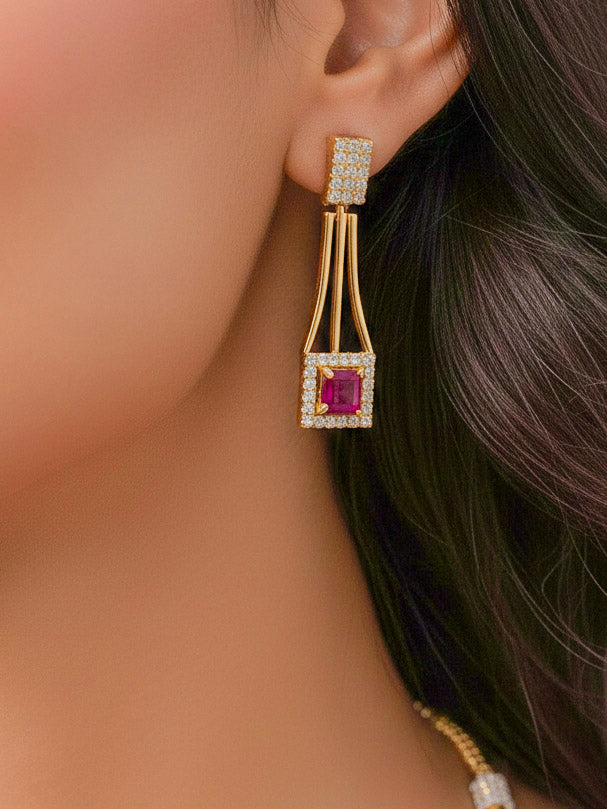Close-up of a woman wearing an ornate Indo-western Red (gold Polish) Collar Layered Diamond jewellery set and earrings with American Diamond and Colored Stone. Party wear outfit completed with a lightweight American diamond necklace. Reception-ready look featuring a statement American diamond jewelry set.