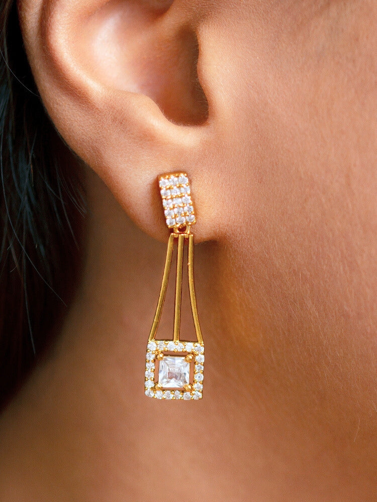 A woman wears the Diora White Necklace Set, a gold party jewelry set featuring a White 2 layer necklace set made with  American diamonds and White gemstones at both the corners, paired with matching earrings. Only her lower face and neck are visible.