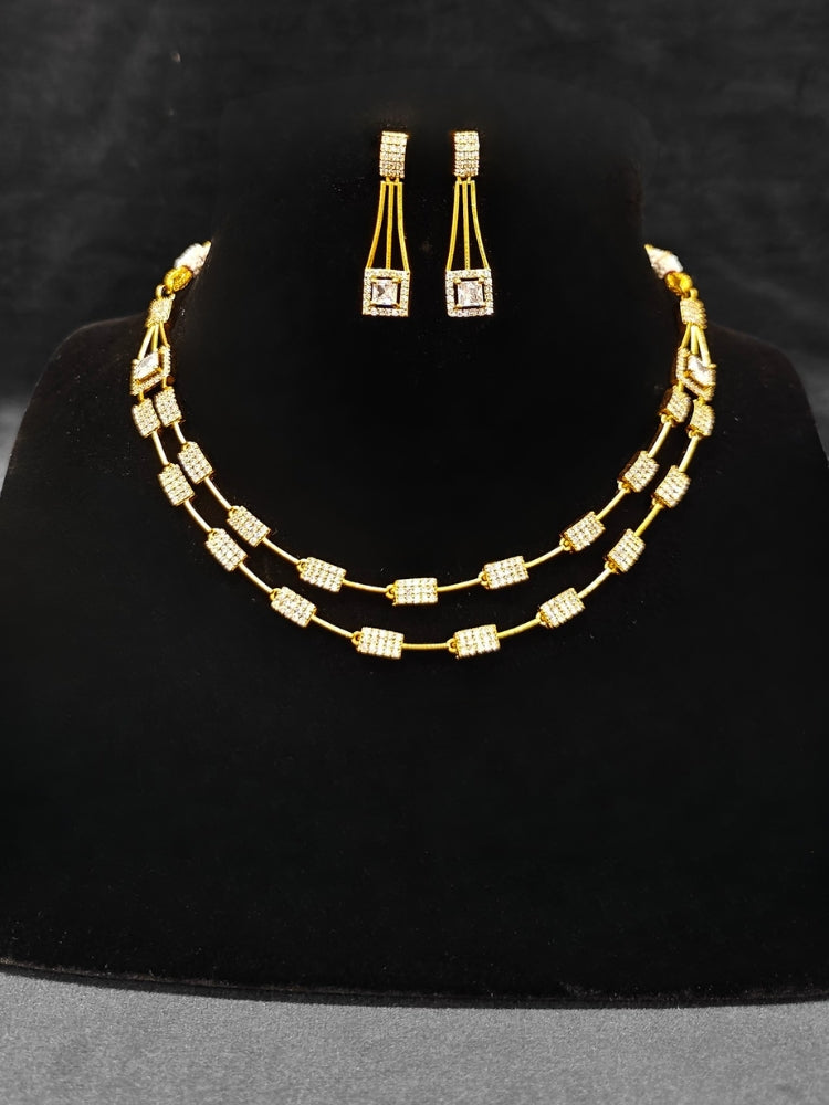 Close-up of an ornate Indo-western white (gold Polish) Collar Layered Diamond jewellery set and earrings with American Diamond. Party wear outfit completed with a lightweight American diamond necklace. Reception-ready look featuring a statement American diamond jewelry set.