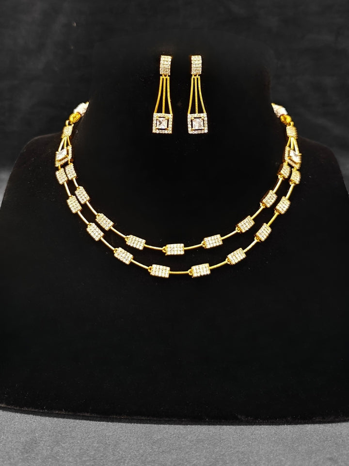 Close-up of an ornate Indo-western white (gold Polish) Collar Layered Diamond jewellery set and earrings with American Diamond. Party wear outfit completed with a lightweight American diamond necklace. Reception-ready look featuring a statement American diamond jewelry set.