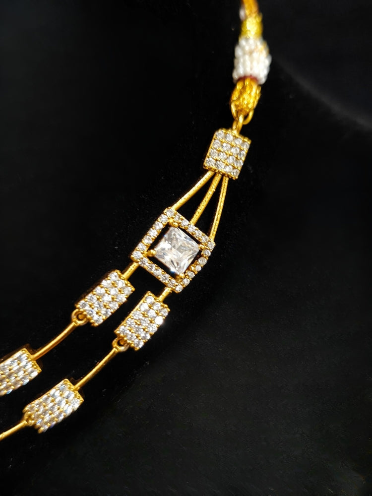 Close-up of an ornate Indo-western white (gold Polish) Collar Layered Diamond jewellery set and earrings with American Diamond. Party wear outfit completed with a lightweight American diamond necklace. Reception-ready look featuring a statement American diamond jewelry set.