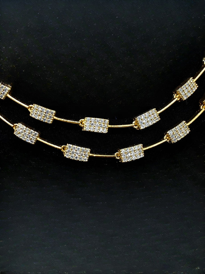 Close-up of an ornate Indo-western white (gold Polish) Collar Layered Diamond jewellery set and earrings with American Diamond. Party wear outfit completed with a lightweight American diamond necklace. Reception-ready look featuring a statement American diamond jewelry set.
