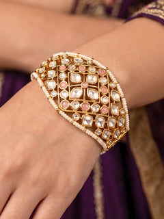 Close-up of a woman wearing an ornate traditional (Gold Polish) Mint Pink Bracelet with Polki, Mint Pink Colored Stone and Pearl. Close-up of a high-quality imitation Polki bracelet for festive wear. Woman showcasing a premium artificial Polki bracelet for wedding celebrations.