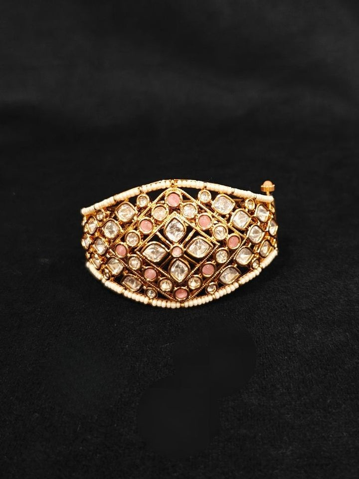 Close-up of an ornate traditional (Gold Polish) Mint Pink Bracelet with Polki, Mint Pink Colored Stone and Pearl. Close-up of a high-quality imitation Polki bracelet for festive wear. Woman showcasing a premium artificial Polki bracelet for wedding celebrations.