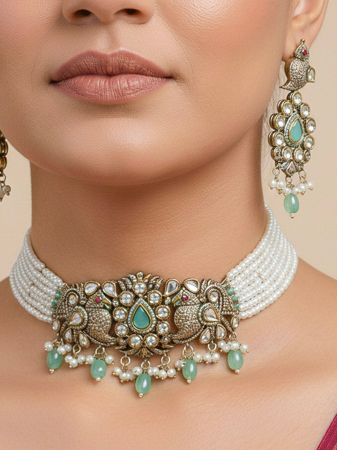 Close-up of a woman wearing an ornate traditional Mint Green (Mehendi Polish)  Choker Diamond jewellery set and earrings with Pearls, Tumble Beads, American Diamond, Kundan and Mint Green Colored Stones. Festive Diwali outfit styled with an American diamond artificial necklace. Close-up of high-quality  artificial American Diamond necklace craftsmanship.