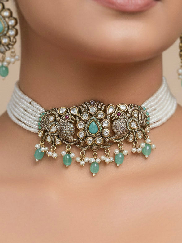 Close-up of a woman wearing an ornate traditional Mint Green (Mehendi Polish)  Choker Diamond jewellery set and earrings with Pearls, Tumble Beads, American Diamond, Kundan and Mint Green Colored Stones. Festive Diwali outfit styled with an American diamond artificial necklace. Close-up of high-quality  artificial American Diamond necklace craftsmanship.