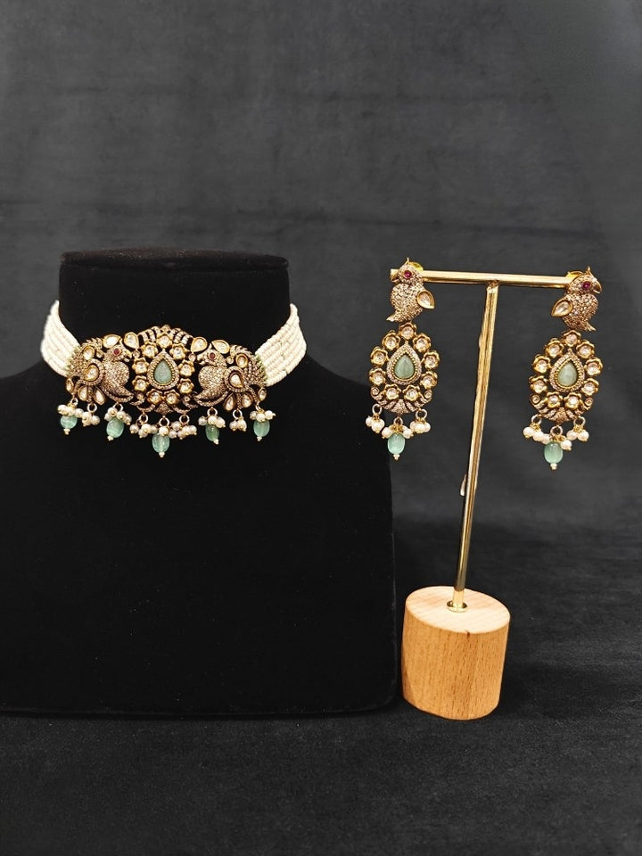 Close-up of an ornate traditional Mint Green (Mehendi Polish)  Choker Diamond jewellery set and earrings with Pearls, Tumble Beads, American Diamond, Kundan and Mint Green Colored Stones. Festive Diwali outfit styled with an American diamond artificial necklace. Close-up of high-quality  artificial American Diamond necklace craftsmanship.