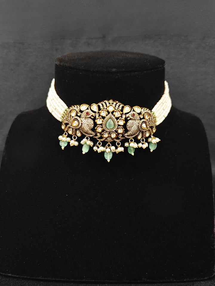 Close-up of an ornate traditional Mint Green (Mehendi Polish)  Choker Diamond jewellery set and earrings with Pearls, Tumble Beads, American Diamond, Kundan and Mint Green Colored Stones. Festive Diwali outfit styled with an American diamond artificial necklace. Close-up of high-quality  artificial American Diamond necklace craftsmanship.